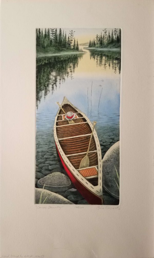 A canoe sits with one end on the rocks on the shore of a lake bordered by tall green trees.