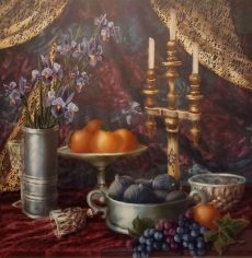 Velvet table is set lavishly with bowls of oranges and figs and bunches of grapes sprawl across the table in front. Three candles and a vase also line the table and a golden and red curtain drape and fold in the background.